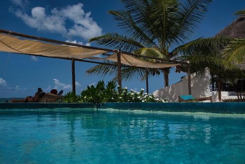a person laying in a chair next to a swimming pool at AVO Boutique Hotel in Dikoni