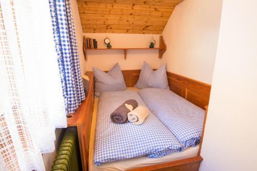 Un ours en peluche posé sur un lit dans une petite maison dans l'établissement AUSZEIT Almchalet, à Ramingstein