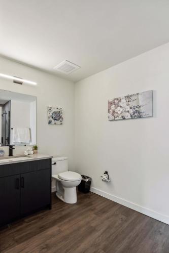 a white bathroom with a toilet and a sink at 3BR Luxury Modern Apartment in Chicago