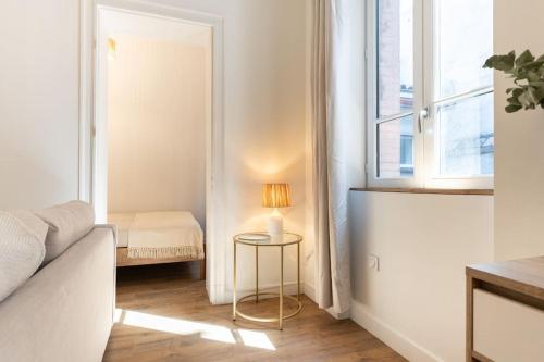 - un salon avec un lit et une table avec une lampe dans l'établissement Le Saint-Sernin Éclatant, à Toulouse