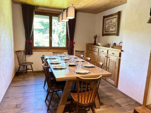 une salle à manger avec une table et des chaises en bois dans l'établissement Les Gets - Appartement rénové 12 pers, 4 ch, parking, WIFI, proche piste - FR-1-623-7, aux Gets