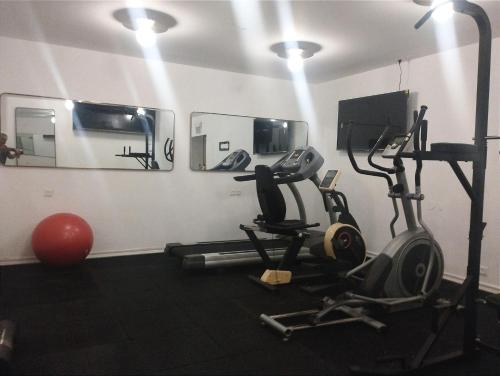 a room with a gym with exercise equipment and mirrors at Adam Boutique Eilat in Eilat