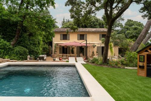 une piscine en face d'une maison avec une cour dans l'établissement Villa provençale 200m2 entièrement climatisé piscine vue Ventoux, à Villeneuve-lès-Avignon