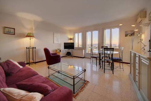 un salon avec un canapé violet et une table dans l'établissement Spacieux 2 Pièces Vue panoramique sur Port de Cannes A1B47, à Cannes