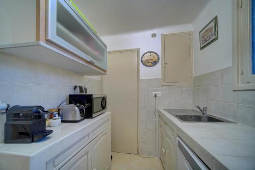 une cuisine avec un évier et un micro-ondes dans l'établissement Spacieux 2 Pièces Vue panoramique sur Port de Cannes A1B47, à Cannes