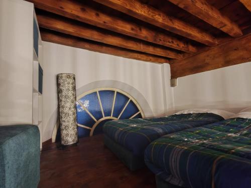 Zimmer mit 2 Betten und einer Balkendecke in der Unterkunft Corte Aranci Deluxe Apartment in Historic Center Of Lucca in Lucca