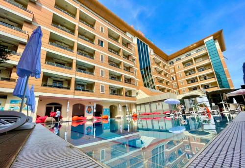 un hotel con piscina frente a un edificio en AMH Hotel Durres, en Durrës