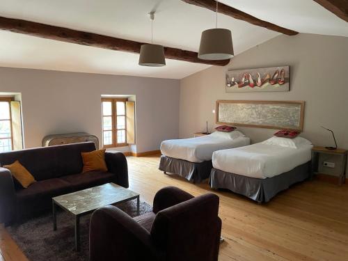 a living room with two beds and a couch at Logis Hôtel Château De Palaja in Carcassonne