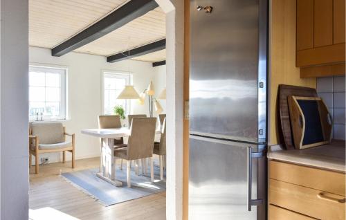 a kitchen and dining room with a refrigerator and a table at 3 Bedroom Nice Home In Ulfborg in Ulfborg