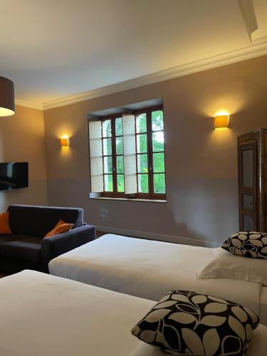 a hotel room with two beds and a window at Logis Hôtel Château De Palaja in Carcassonne