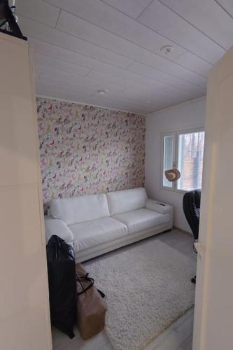 a living room with a white couch and a window at Talo kaikilla mukavuuksilla in Joensuu