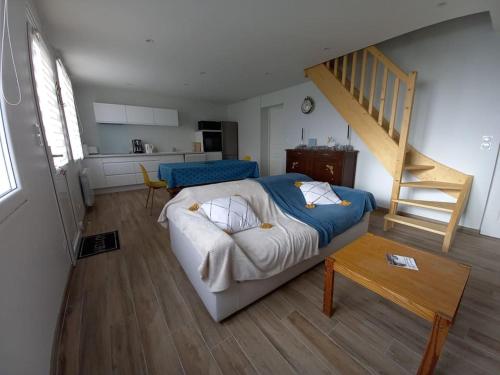 - une chambre avec un lit et un escalier dans l'établissement L'Oeil du Mont Maison vue sur le Mont Saint Michel et sa baie, à Champeaux