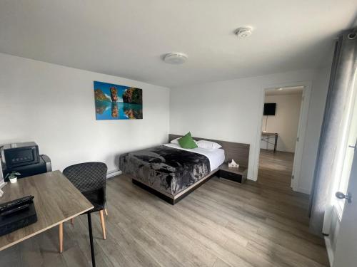 a bedroom with a bed and a desk and a table at Motel Saint Bruno in Saint-Bruno-de-Montarville