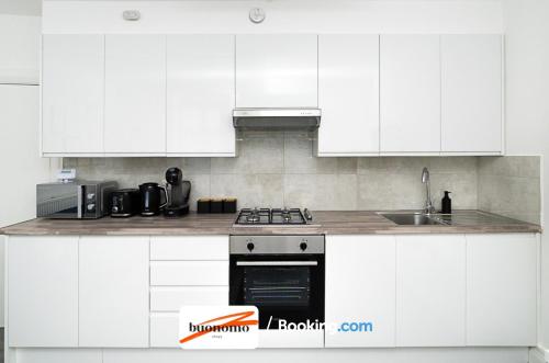 a white kitchen with a stove and a sink at Three Bedroom Apartment At Buonomo Stays Short Lets & Serviced Accommodation With Netflix & Games in London