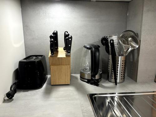 a kitchen counter with a knife block and utensils at City Apartment am Fluss in Frankfurt/Main
