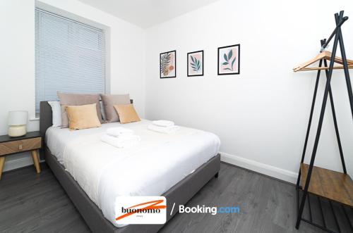 a bedroom with a bed with white sheets at Three Bedroom Apartment At Buonomo Stays Short Lets & Serviced Accommodation With Netflix & Games in London