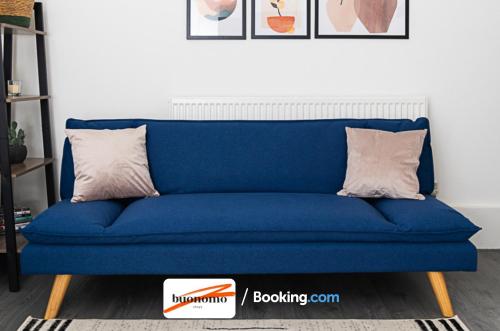 a blue couch in a living room with two pillows at Three Bedroom Apartment At Buonomo Stays Short Lets & Serviced Accommodation With Netflix & Games in London