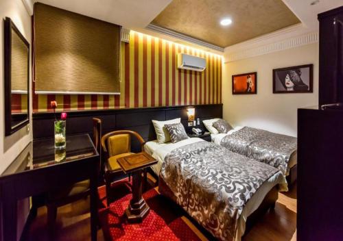 a hotel room with two beds and a desk at Royal Day in 6th Of October