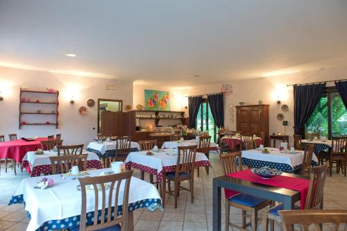 a dining room with white tables and chairs with red and blue at Residence Alesi in Malcesine