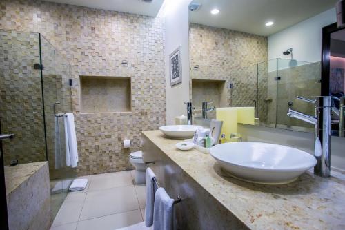 a bathroom with two sinks and a toilet and a shower at Marival Distinct All-Suites & World Spa - Handwritten Collection in Nuevo Vallarta 