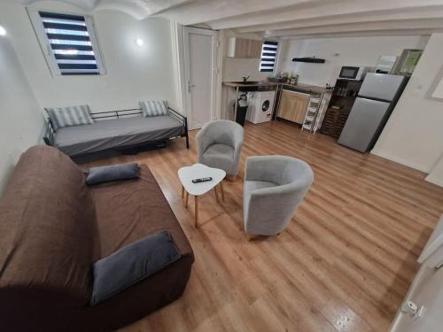 un salon avec un canapé et des chaises et une cuisine dans l'établissement Magnifique Appartement T2, à Marseille