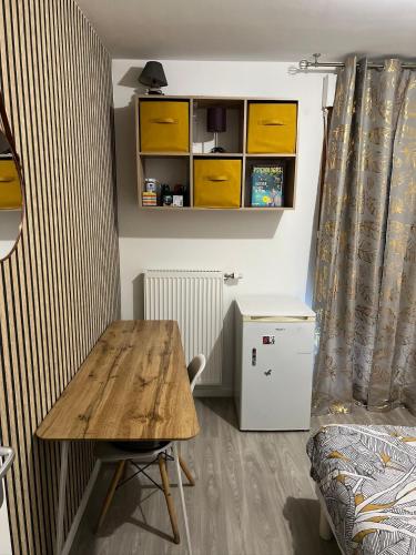 Cette petite chambre comprend une table en bois et un lit. dans l'établissement Chambre à louer, dans un appartement partagé, à Villepinte