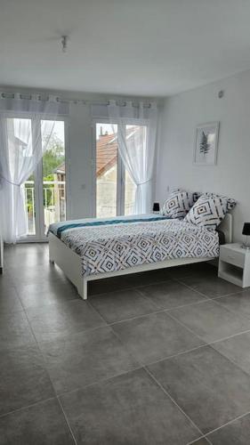 une chambre avec un lit dans une pièce avec des fenêtres dans l'établissement Agréable studio proche Orly 