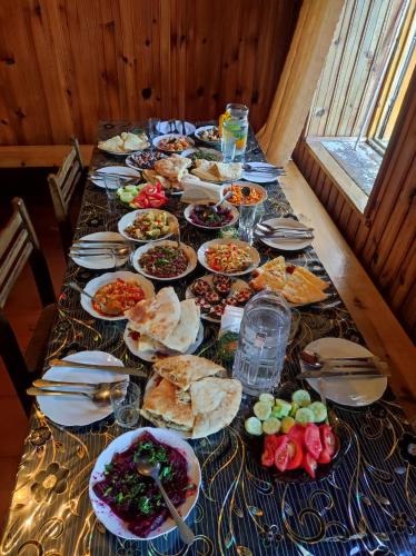 ein langer Tisch mit Tellern voller Essen darauf in der Unterkunft Adishi Zhora Kaldani Guest House in Adishi