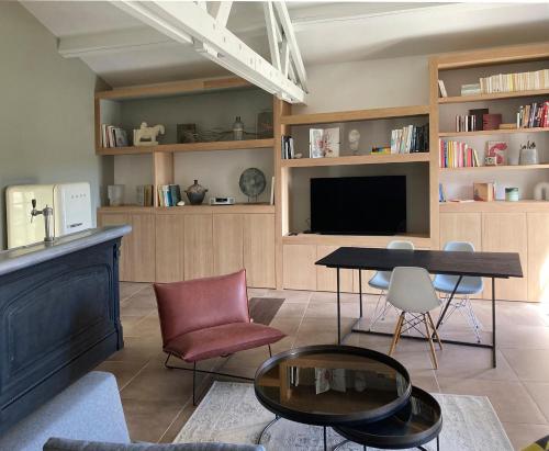 - un salon avec une table, des chaises et une télévision dans l'établissement le secret du chat, à Cordes-sur-Ciel