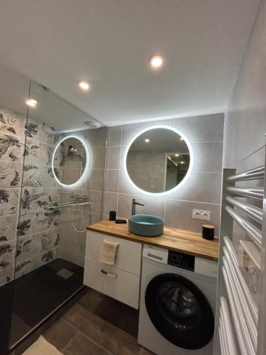 La salle de bains est pourvue d'un lave-linge et de deux miroirs. dans l'établissement Au cœur des Caladons, à Lunel