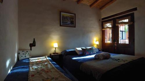 a bedroom with two beds and a window at La Paleta del Pintor Hosteria in Maimará