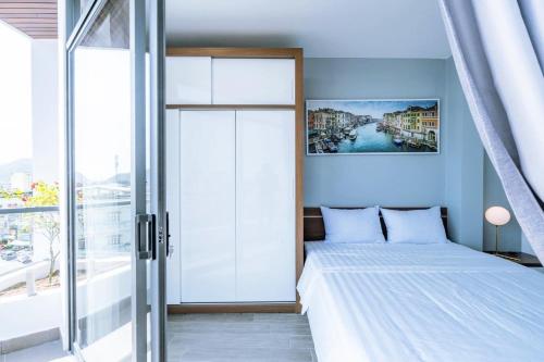 a bedroom with a bed and a large window at Hoàng Anh Hotel in Nha Trang