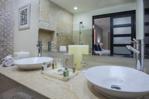 a bathroom with two sinks and a large mirror at Marival Distinct All-Suites & World Spa - Handwritten Collection in Nuevo Vallarta 