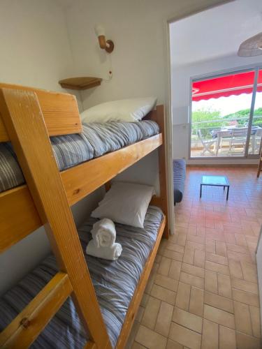 Cette chambre comprend 3 lits superposés et une terrasse. dans l'établissement Pacific 1-Studio cabine, vue mer, parking, à La Grande Motte