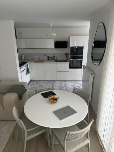 - une table et des chaises blanches dans une petite cuisine dans l'établissement Appartement Cosy, proche Stade de France, à Saint-Denis