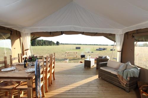 a tent with a table and a couch and a table and chairs at Summerfield in Sedgeford
