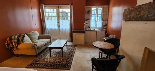 a living room with a couch and a table at La Pelisserie, Chambres d'Hotes in Saint-Antonin-Noble-Val