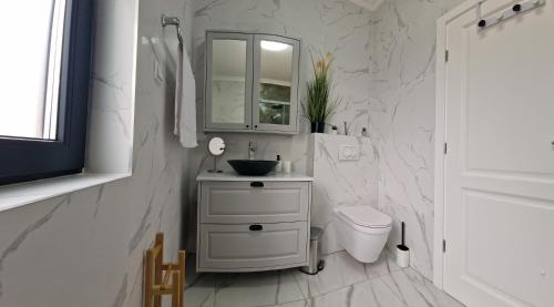 a white bathroom with a sink and a toilet at Luxury Villa Aramis with jacuzzi in Malinska in Sveti Ivan