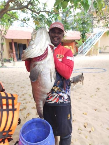 a man holding a fish in his arms at Dolphin Village in Kalpitiya