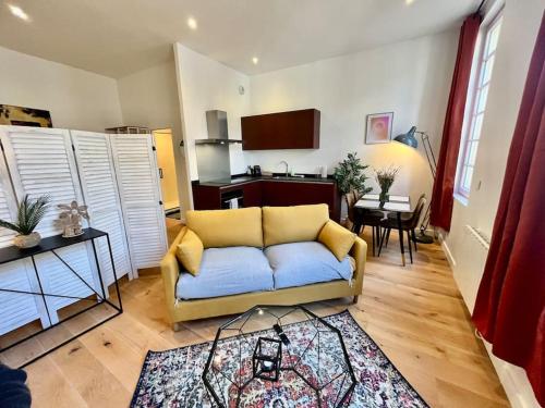 un salon avec un canapé et une cuisine dans l'établissement Petit loft Vieux Bordeaux, à Bordeaux