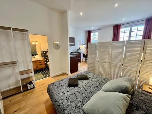 une chambre avec un lit avec des oreillers dessus dans l'établissement Petit loft Vieux Bordeaux, à Bordeaux