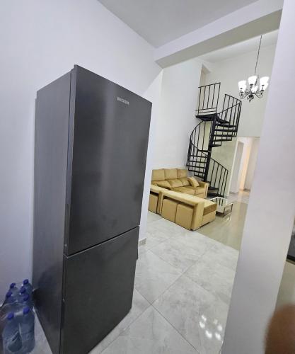 a black refrigerator in a living room with a couch at Safim Suites in Plaque