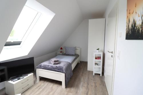 a small bedroom with a bed and a window at Boddenblick 9 a in Fuhlendorf