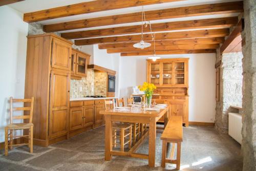 a kitchen with a wooden table and chairs at Gites de france d'arzenc d'apcher in Arzenc-dʼApcher