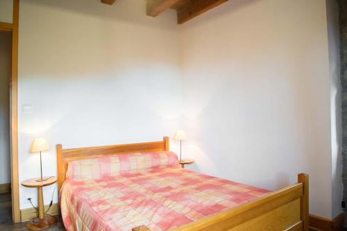 a bedroom with a bed and two lamps on tables at Gites de france d'arzenc d'apcher in Arzenc-dʼApcher