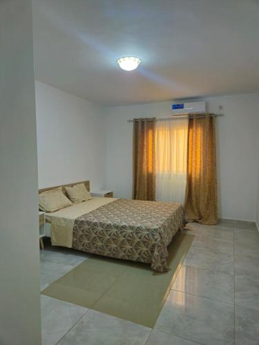 a bedroom with a bed and a window with curtains at Safim Suites in Plaque