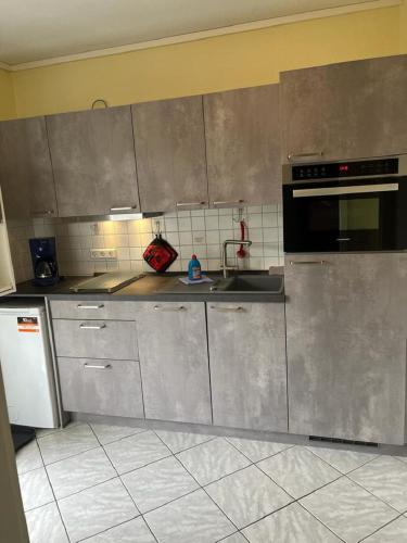 a kitchen with stainless steel cabinets and a sink at Kiebitzstieg 22, Nr5 in Dorum-Neufeld