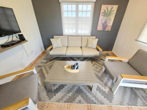 una sala de estar con un sofá y una mesa en Private Pool Home Beach 15 min Drive, en Cabo Rojo