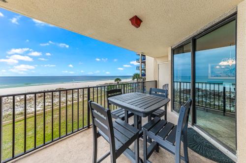 une table et des chaises sur un balcon avec vue sur la plage dans l'établissement Phoenix V Vacation Rental Condos, à Orange Beach