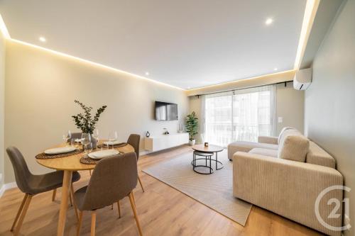 un salon avec une table et un canapé dans l'établissement Modern Appartment, Central, 10 Min Walk to Beach, à Vallauris